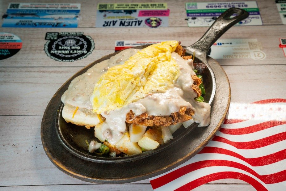 Breakfast skillet topped with eggs and sausage gravy
