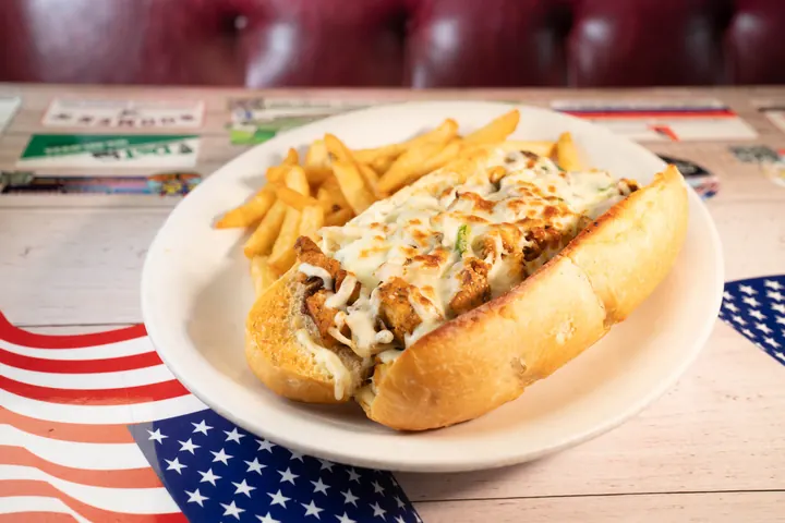 Cheesesteak sandwich served with fries