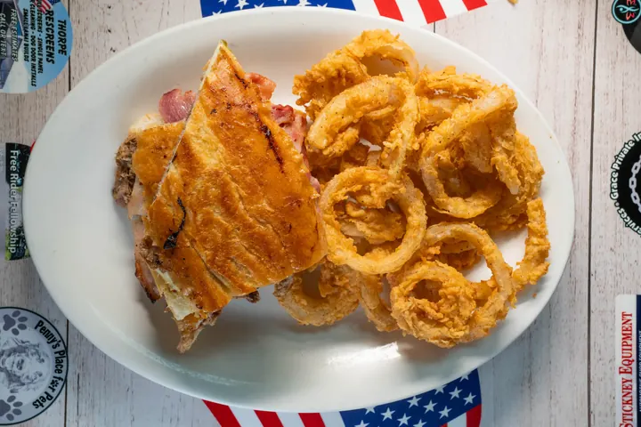 Grilled diner sandwich served with onion rings