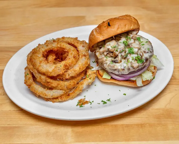 Mushroom Swiss burger served with onion rings